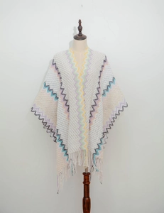 Close-up of knit shawl with colorful wave patterns and delicate tassel hem details