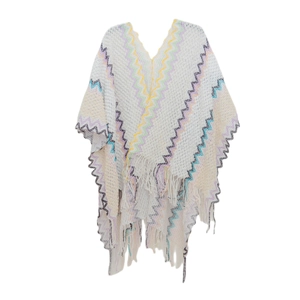 Detail of V-neck knitted poncho featuring colorful chevron patterns and tassel fringe hem