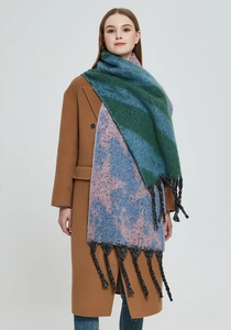 Detail of multi-color thick knit scarf with bold tassels and soft textured wool fabric