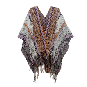 Close-up of geometric knit pattern and fringe hem on bohemian style poncho