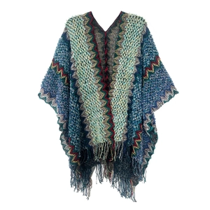 Detailed close-up of bohemian zigzag knit pattern with long fringe tassels on white