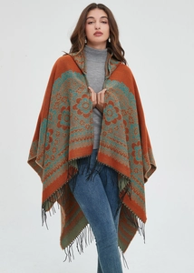 Détail d'un poncho à capuche avec motifs floraux vintage et longues franges noires