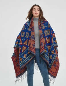 Detail of bohemian knit shawl with vibrant geometric patterns and black fringe tassels