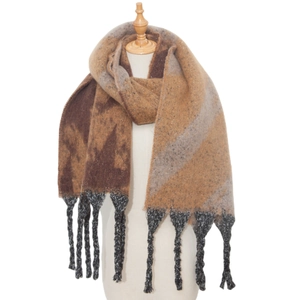 Detailed texture of thick knit scarf with brown patchwork blocks and long twisted tassels