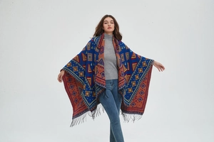 Detail of bohemian geometric jacquard knit poncho with fringe trim and hood