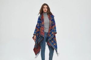 Detail of hooded poncho featuring ethnic geometric patterns and long black fringe trim