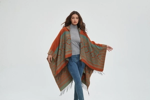 Détail d'un poncho en tricot à motifs floraux avec de longues franges noires élégantes