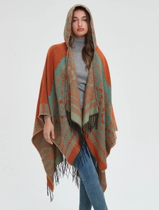 Détail du poncho à capuche avec motif jacquard ethnique et longues franges noires