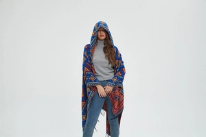 Close-up of blue bohemian hooded poncho with colorful geometric patterns and tassel fringe