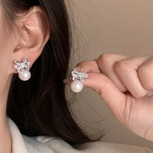 Elegant silver bow stud earrings with sparkling crystals and a white round pearl drop