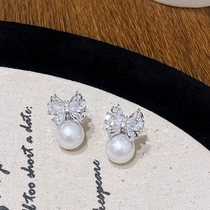 Elegant silver bow earrings with sparkling zircon crystals and round white pearls