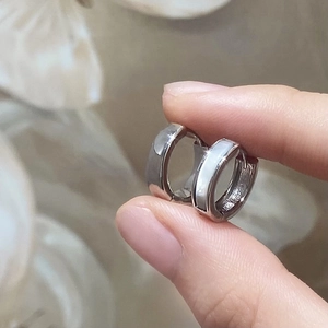 Elegante silberne Huggie-Ohrringe mit Perlmutteinlage in einer Lifestyle-Handansicht