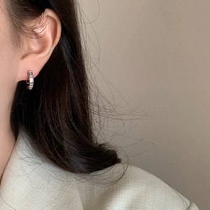 Close-up of sparkling silver huggie hoop earrings with micro-pave cubic zirconia inlay