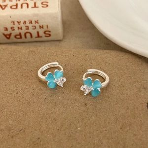 Detailed shot of blue cat eye stone four-leaf clover earrings with zircon center and silver hoops