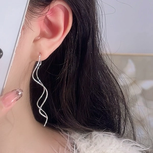 Orecchini a filo ondulati in argento con pavé di zirconi indossati da modella