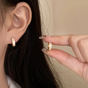 Minimalist gold hoop earrings with white shell inlay worn by model for daily fashion