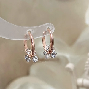 Gros plan détaillé de boucles d'oreilles géométriques rose doré avec zircons micro-sertis