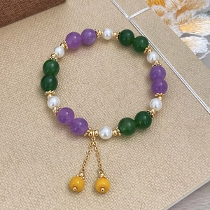 Detailed close-up of a colorful natural stone bead bracelet with silk tassels and pearls