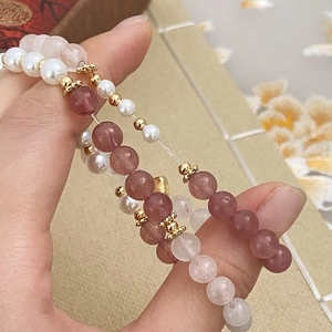 Détail de bracelets faits main avec cristaux roses, perles et accents dorés