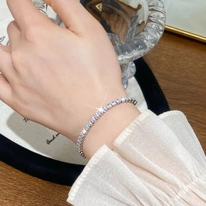 Elegant silver tennis bracelet with sparkling square zirconia worn on a female wrist
