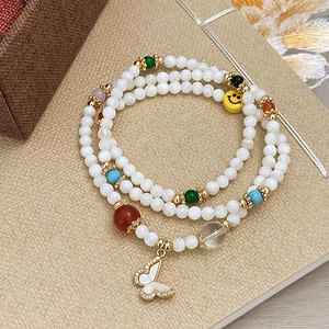 Elegante bracciale multistrato di perle con ciondolo a farfalla dorata e perla smile gialla
