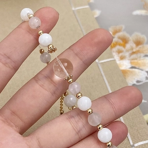 Elegant beaded bracelet featuring natural stones pearls and gold spacers on a textured background
