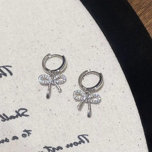 Gros plan de boucles d'oreilles nœud en argent serties de zircons et fermoir clip