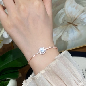 Elegant rose gold tennis bracelet with circular halo setting and shimmering zircon stones