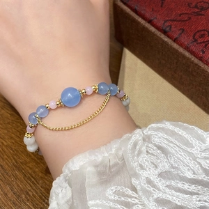 Elegant beaded bracelet with blue and pink stones and a gold chain tassel fringe