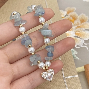 Handmade bracelet featuring blue crystals, white pearls, and a heart zircon pendant