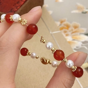 Elegante bracciale di agata rossa con perle e ciondolo dorato su filo elastico