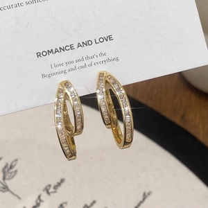 Detail of double-layer gold hoop earrings with baguette-cut pavé cubic zirconia