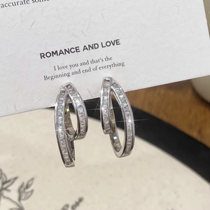 Macro detail of silver geometric double hoop earrings with pave-set baguette zircons