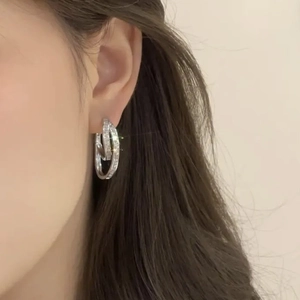 Irregular double hoop earrings with pavé cubic zirconia worn on ear for a luxury style