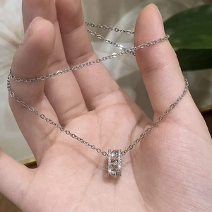 Vue détaillée d'un pendentif circulaire orné de zircons brillants sur chaîne argent