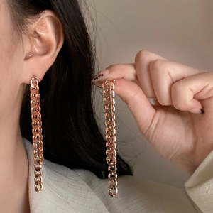 Elegant rose gold Cuban link chain drop earrings shown worn on ear and held in hand