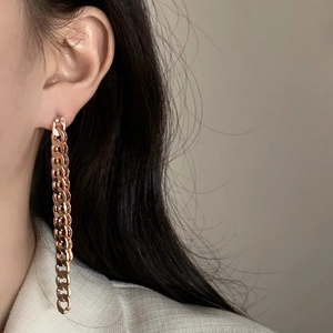 Rose gold chain earrings featuring Cuban link design worn by a model in profile view