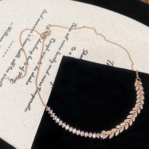 Detail view of wheat leaf necklace with zircon stones on an elegant velvet display
