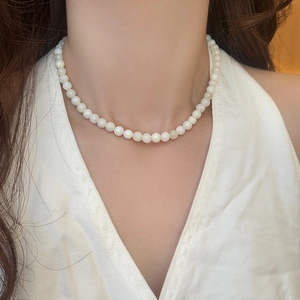 French style elegant white beaded necklace worn by a model on a white halter top