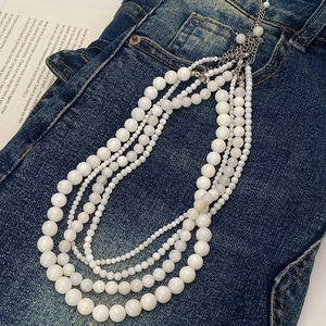 Detail view of multi-layer white beaded necklace with silver adjustable lobster clasp