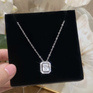 Halo setting necklace with emerald cut zircon pendant on black velvet display board