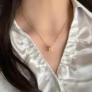 Collier géométrique plaqué or avec pendentif en zircon étincelant porté par un mannequin