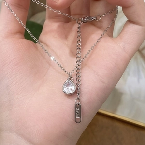 Handheld view of silver stainless steel necklace with sparkling waterdrop zircon pendant