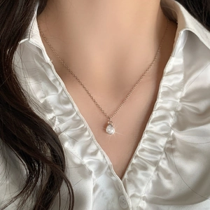 Exquisite teardrop zircon pendant necklace in silver plating worn on white silk shirt