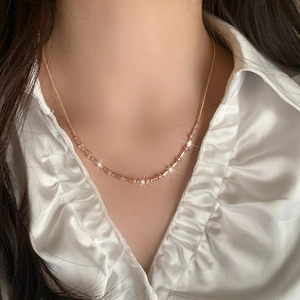 Elegant rose gold necklace with rectangular and round cubic zirconia stones worn by model