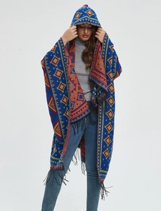 Close-up of bohemian hooded poncho featuring vibrant geometric jacquard and fringe detail