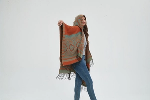 Détail d'un poncho en tricot vintage avec capuche et finitions élégantes à franges noires