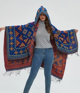 Detail of bohemian hooded poncho with blue geometric patterns and long black fringes