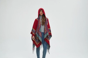 Détail d'un poncho bohème à capuche avec motifs de cœurs rouges et franges noires