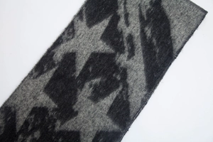 Detailed macro view of the knitted star pattern and thick fringe on this warm winter scarf